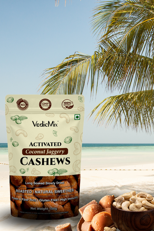 Packaging of VedicMix Activated Coconut Jaggery Cashews with cashews visible in the foreground and a tropical beach background.